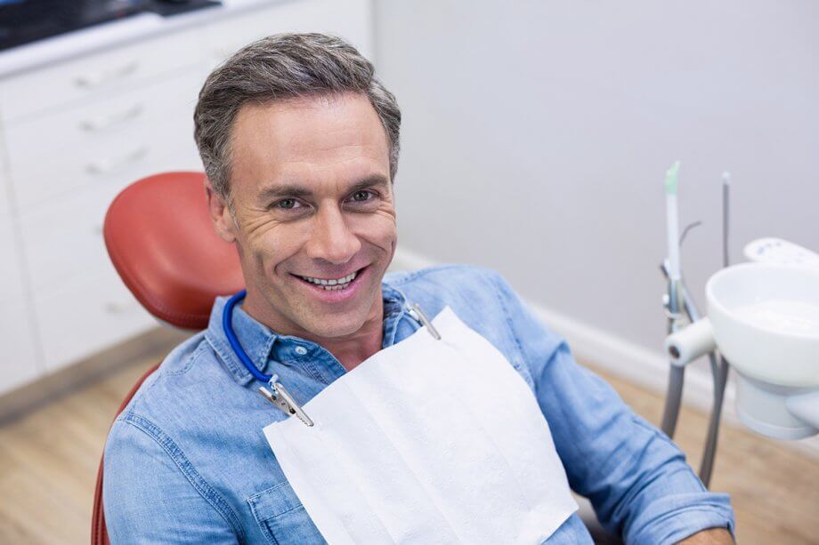 smiling male patient in dental chair